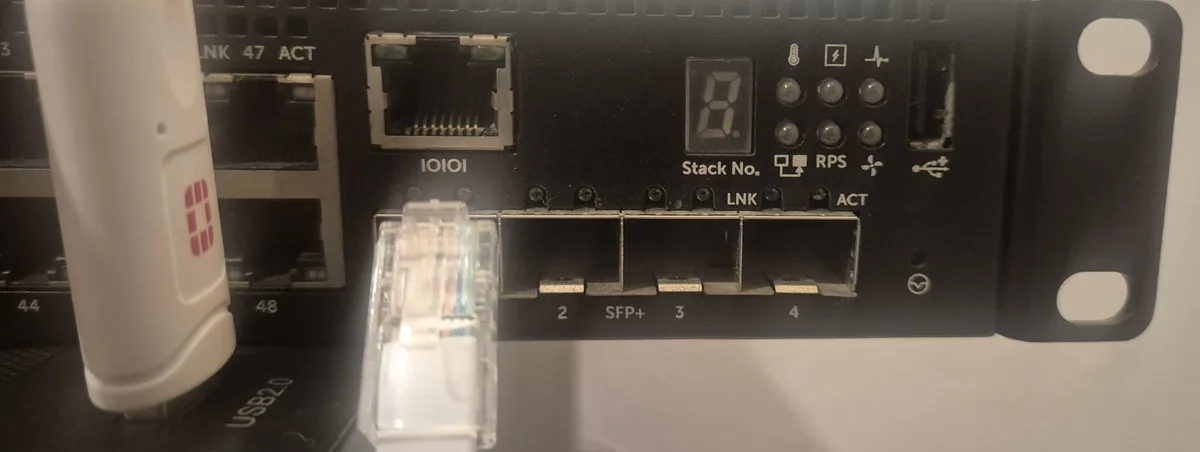 Switch'in ön yüzü: IOIOI işaretli RJ45 konsol portu ve hemen önünde konsol kablosunun RJ45 ucu, sağda switch'in kendi USB girişi, solda Ethernet portları ve bilgisayarın USB girişine takılı kablonun USB ucu